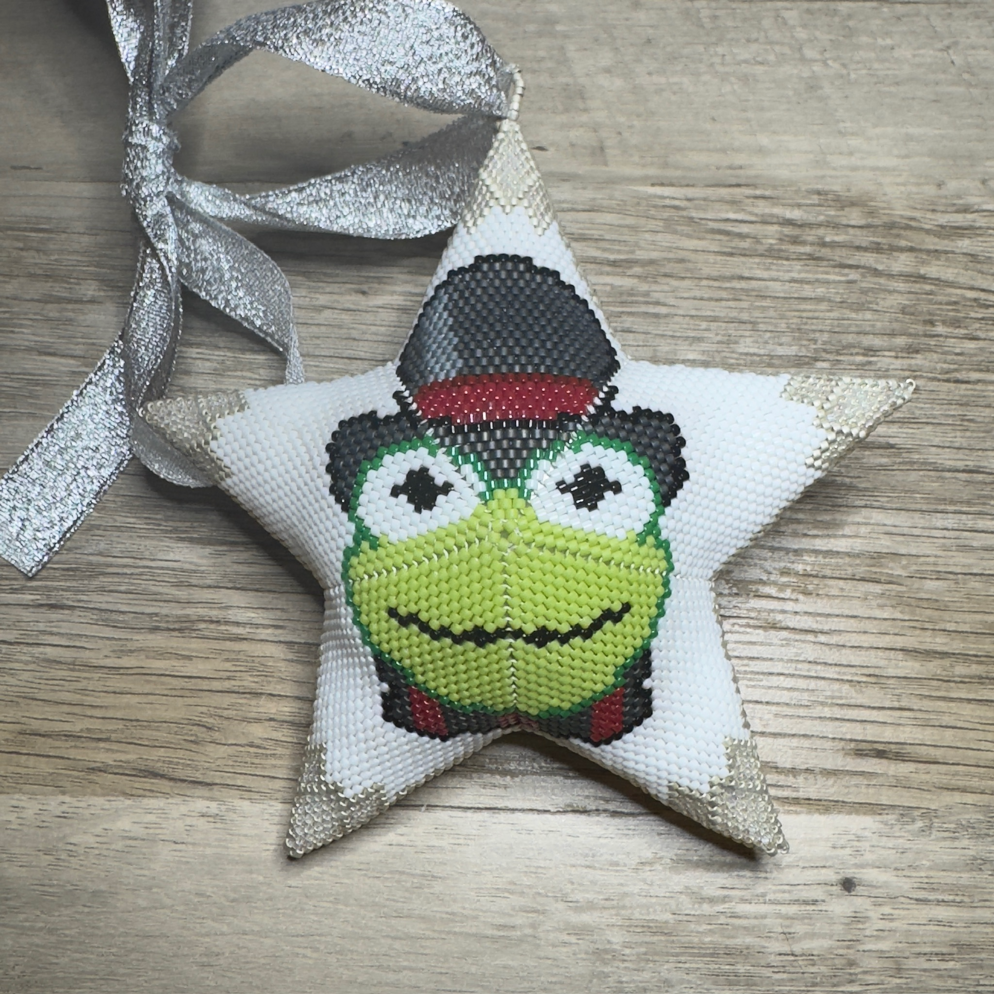 Beaded star ornament featuring Kermit the Frog with silver ribbon